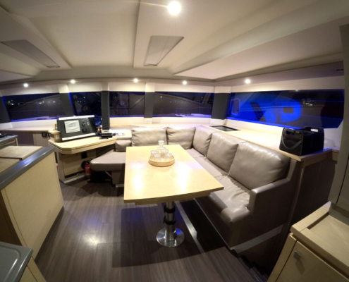 Modern saloon with wraparound windows and evening accent lighting.